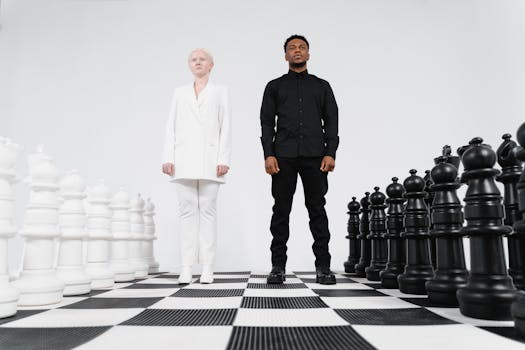 Two people as chess pieces on a giant chessboard symbolizing strategy and competition.