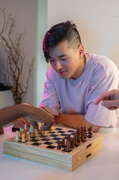 A group of friends playing chess indoors, concentrating on strategy.