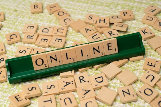 Scrabble tiles spelling 'online' on a green tray amidst scattered tiles, symbolizing digital connectivity and language.