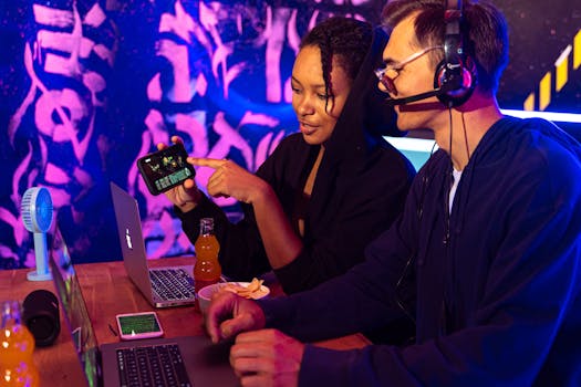 Two people engaged in an online gaming session with laptops and mobile devices in a vibrant, neon-lit room.