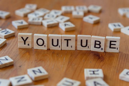 Wooden letter tiles spelling 'YOUTUBE' on a wooden surface, symbolizing video sharing and streaming.